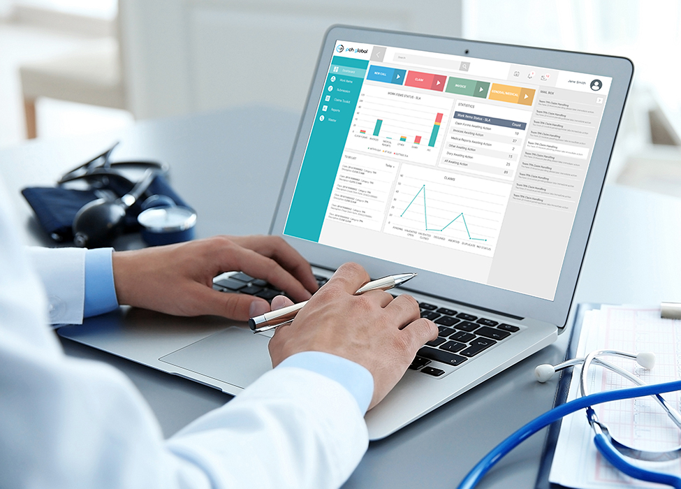 automated claims processing | Close up at a doctor's desk with laptop showing screen. Exela's PCH Global is on screen. 